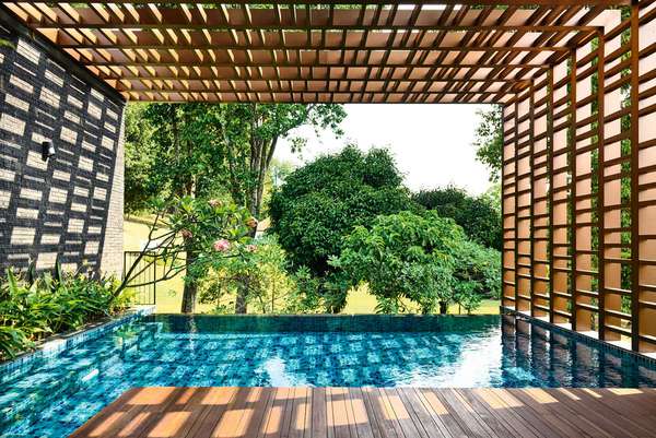 Beim Viewing Back House in Singapur  kommt man direkt vom Wohnzimmer  über die überdachte Terrasse in den  Pool. Die Lichtreflexionen sind im  Konzept inbegriffen. hyla.com.sg
