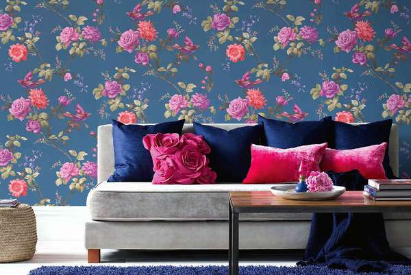 Wie ein exklusiver Indoor-Rosengarten inszeniert sich die Tapete  »Oriental Blue« mit Vogel-Motiv und voll erblühter Flora. Statement-Wand. grahambrown.com